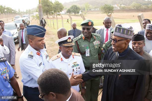Nigerian President Mohammadu Buhari shakes hands with Airforce Chief, Air Marshal Sadique Abubakar, among other service chiefs upon his arrival at...