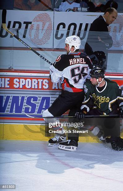 Denis Hamel of the Buffalo Sabres gets slamed up into the glass by Grant Marshall of the Dallas Stars during the game at the HSBC Arena in Buffalo,...