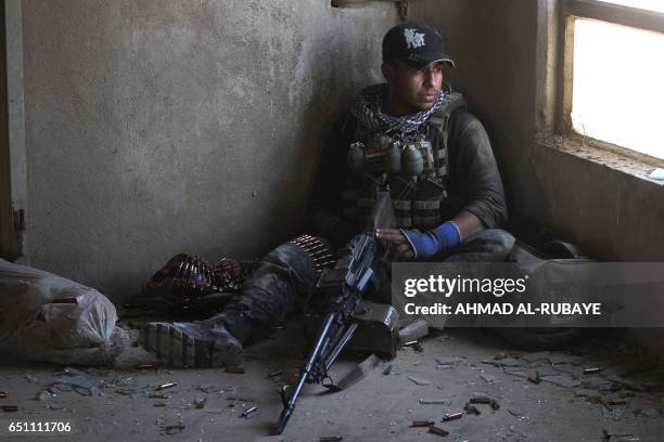 Fighter from Iraq's elite Counter-Terrorism Service takes a position inside a building in the Shuhada neighbourhood of west Mosul on March 10 during...