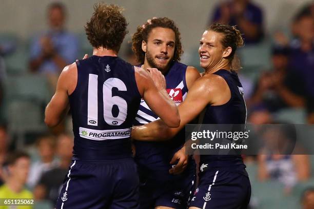 Griffin Logue of the Dockers is congratulated by David Mundy and Nathan Fyfe after kicking his first goal during the JLT Community Series AFL match...