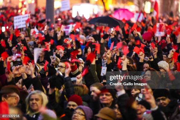 People with red cards and banners participate in the Miedzynarodowy Strajk Kobiet on March 08, 2017 in Warsaw, Poland. IWS is an initiative...