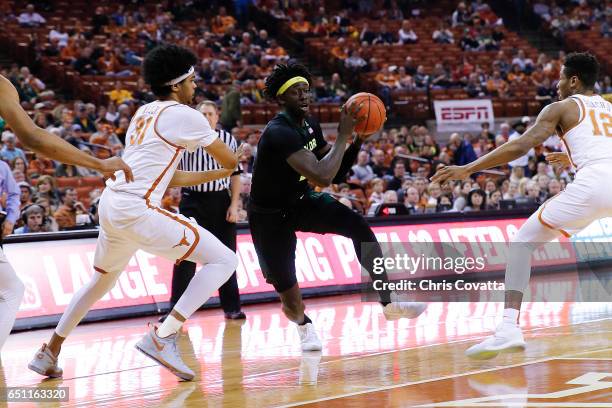 Johnathan Motley of the Baylor Bears drives between Jarrett Allen and Kerwin Roach Jr. #12 of the Texas Longhorns at the Frank Erwin Center on March...