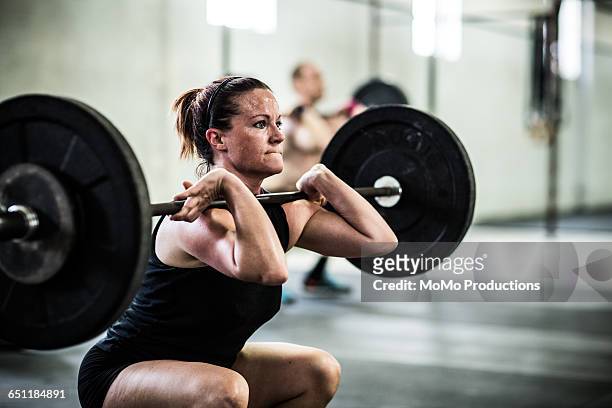 gym - woman doing front squats - weight lifting stockfoto's en -beelden