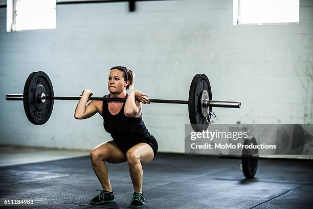 gym - woman doing front squats - gewichte stock-fotos und bilder