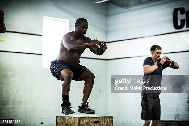 gym - men doing box jumps - calções de corrida imagens e fotografias de stock