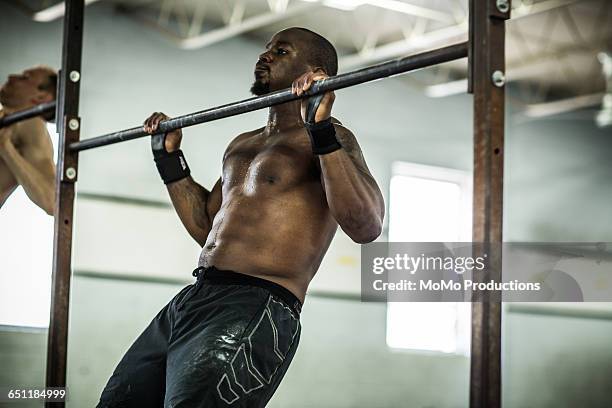 gym - man doing pull ups - pull ups stock pictures, royalty-free photos & images