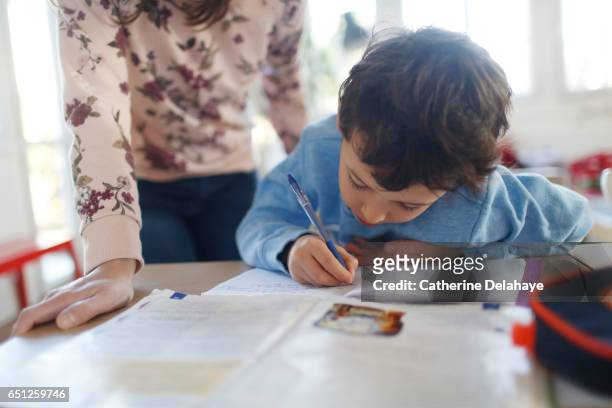 a boy doing his homeworks - faire ses devoirs photos et images de collection
