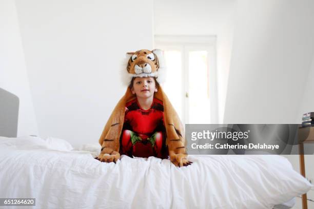 a disguised boy playing on a bed - france costume stockfoto's en -beelden