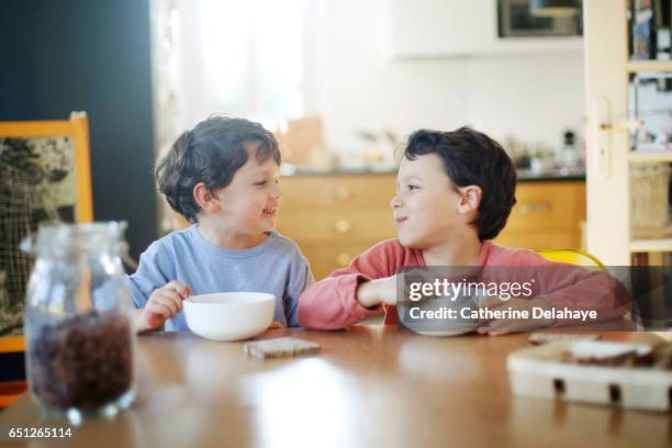 2 brothers having their breakfast - children eating breakfast stock-fotos und bilder