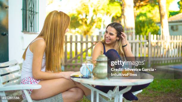 two beautiful girls having a healthy breakfast in a bright garden - estudando stock pictures, royalty-free photos & images