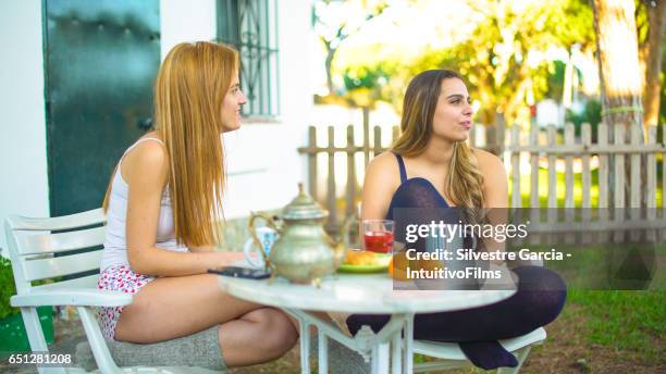 two beautiful girls having a healthy breakfast in a bright garden - estudando stock pictures, royalty-free photos & images