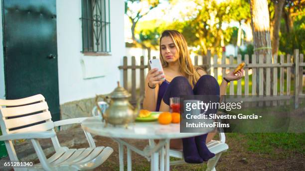 a beautiful girl having a healthy breakfast in a bright garden - estudando stock pictures, royalty-free photos & images