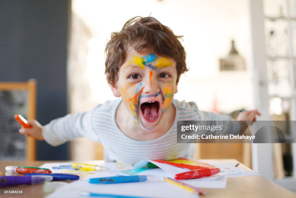A boy playing with felt pens