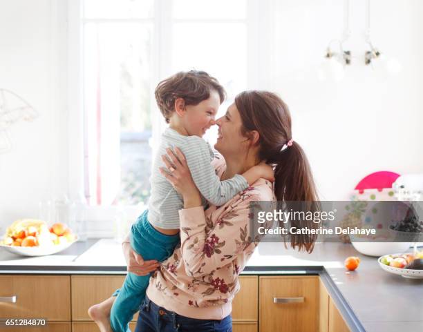 a mom hugging her son in the kitchen - family with one child imagens e fotografias de stock
