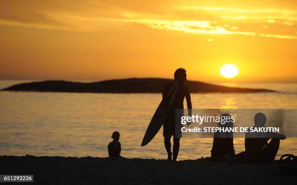 Sunbathers enjoy the sunset from Camps Bay in Cape Town on December 3, 2009. AFP PHOTO / STEPHANE DE SAKUTIN