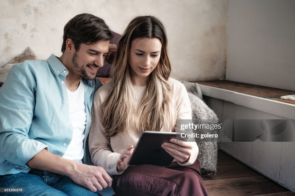 Schöne junge Paar miteinander Tablet Zuhause suchen