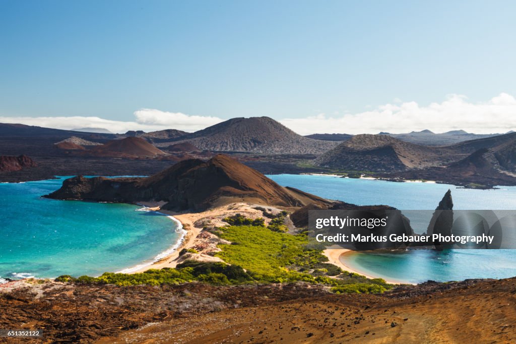 View on the volcanic landscape of Bartolome Island with famous Pinnacle Rock and Golden Beach, Galapagos Islands, Ecuador