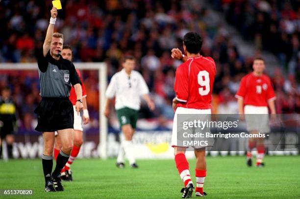 Referee Jacek Granat cautions Switzerland's Massimo Lombardo