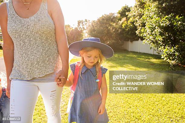little girl in uniform walking to school with mum - first day of school australia stock pictures, royalty-free photos & images