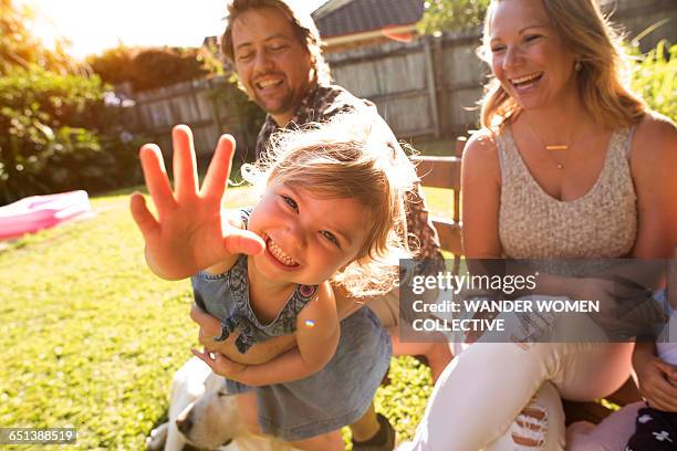 young girl reaching our with mum and dad - happy moment stock-fotos und bilder