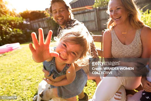 young girl reaching our with mum and dad - australian family home stockfoto's en -beelden