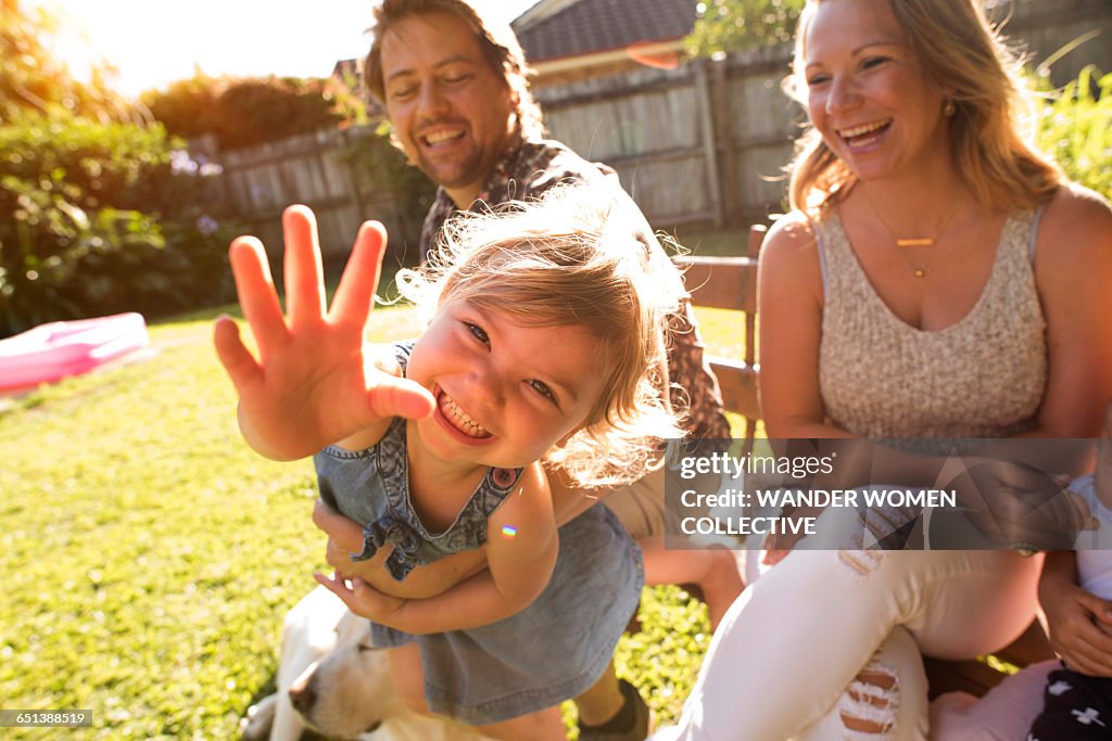 Young girl reaching our with mum and dad