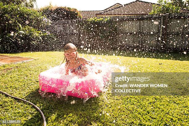 girl in australian backyard baby pool splashing - planschbecken stock-fotos und bilder