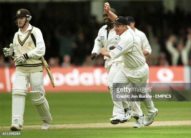 Gloucestershire's Mark Alleyne & Martyn Ball celebrate claiming the wicket of Surrey's Alistair Brown.