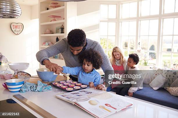 family baking cake in kitchen at home together - köksvåg bildbanksfoton och bilder