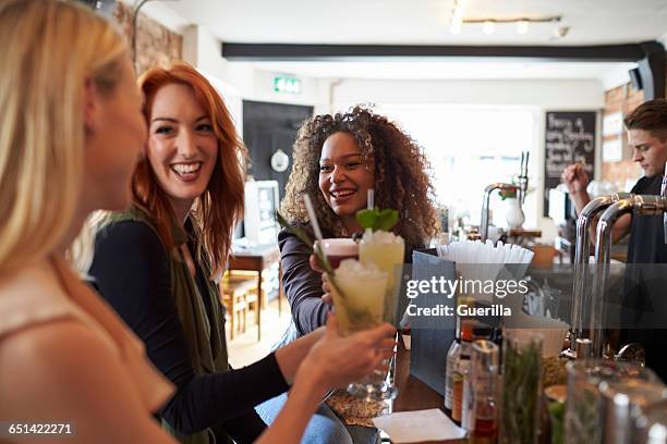 group of female friends enjoying drink in cocktail bar - mojito stock pictures, royalty-free photos & images