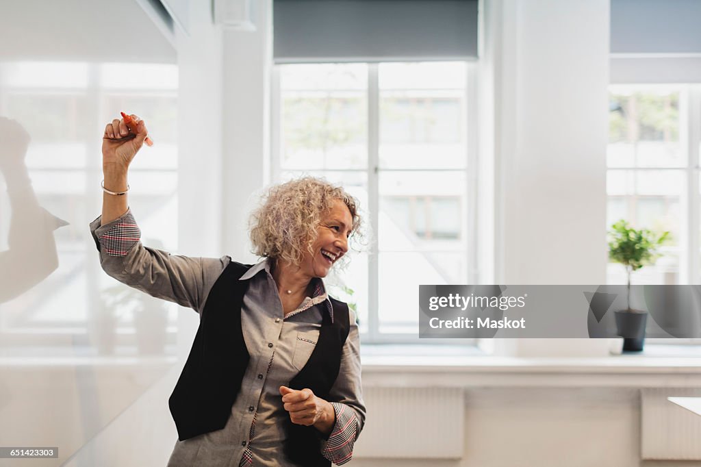 Smiling teacher writing on whiteboard in language class