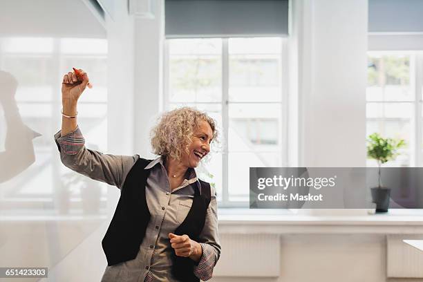 smiling teacher writing on whiteboard in language class - senior adult bildbanksfoton och bilder