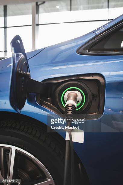 battery charger in blue electric car at showroom - fuel efficient stock-fotos und bilder