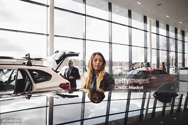 customers looking at cars in showroom - toonzaal stockfoto's en -beelden