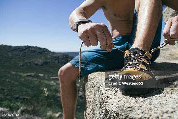 close up of a climber tying shoelaces of his climbing shoes - free climbing stock pictures, royalty-free photos & images