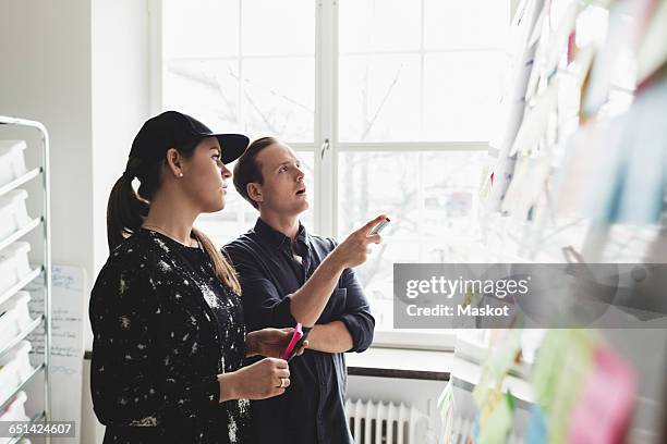 businesspeople discussing while looking at whiteboard in office - engineers brainstorming stock pictures, royalty-free photos & images