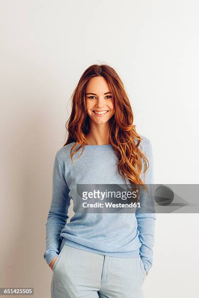 portrait of smiling young woman with hands in her pockets - three quarter length stock pictures, royalty-free photos & images