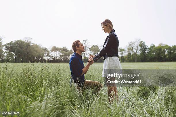 man proposing marriage to young woman - prometido relación humana fotografías e imágenes de stock