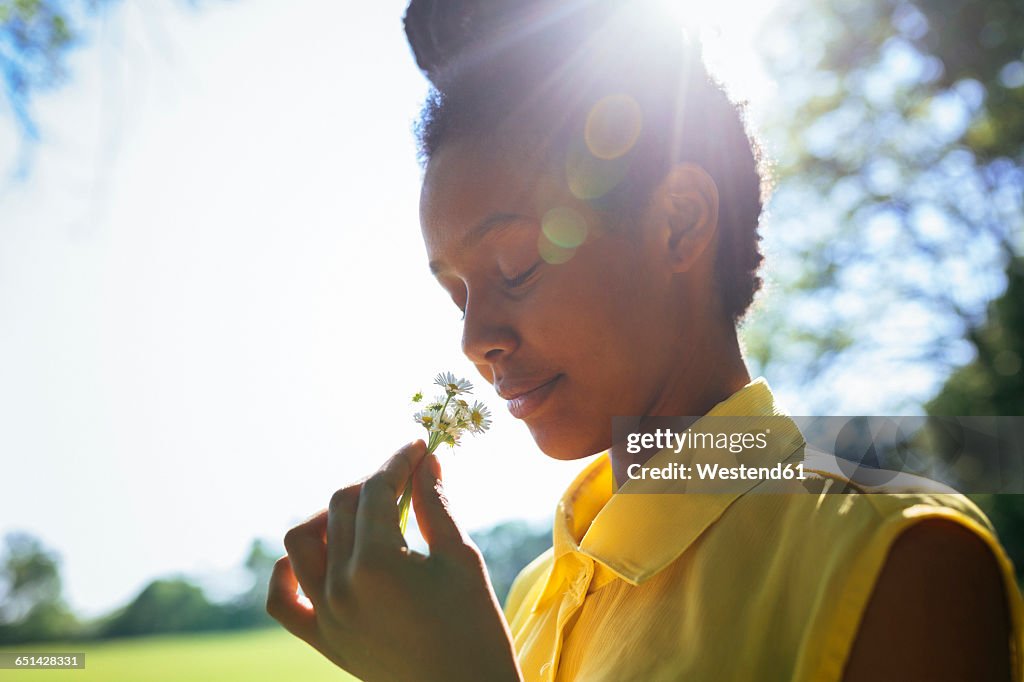 Portrait of smiling young woman smelling flowers