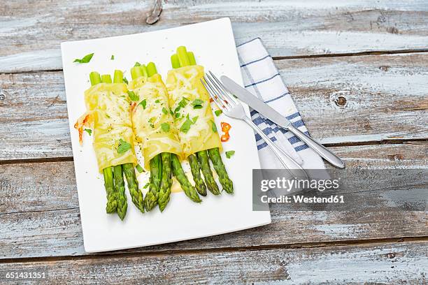 cannelloni filled with green asparagus, gratinated with cheese on plate - cannelloni stock pictures, royalty-free photos & images