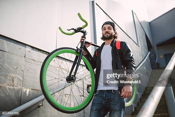 young man carrying fixie bike - carrying bike stock pictures, royalty-free photos & images