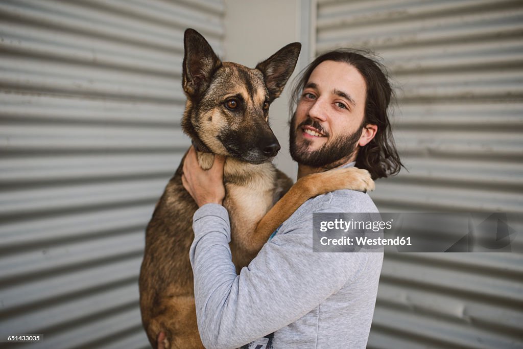 Portrait of young man holding dog
