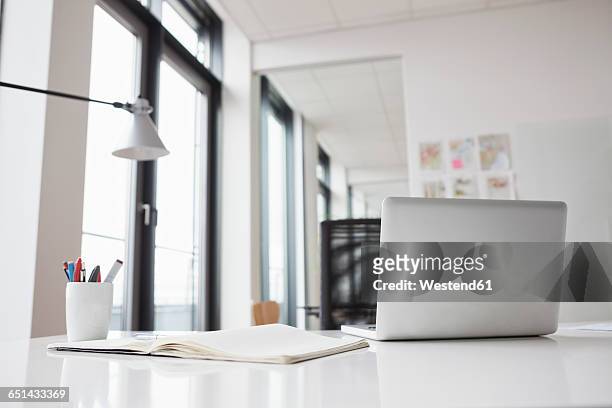 laptop and notebook on office desk - desk stock pictures, royalty-free photos & images