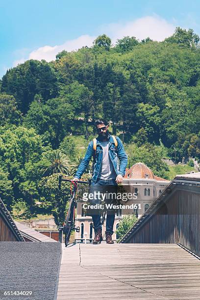 spain, bilbao, man with racing cycle on a bridge - biscaglia foto e immagini stock