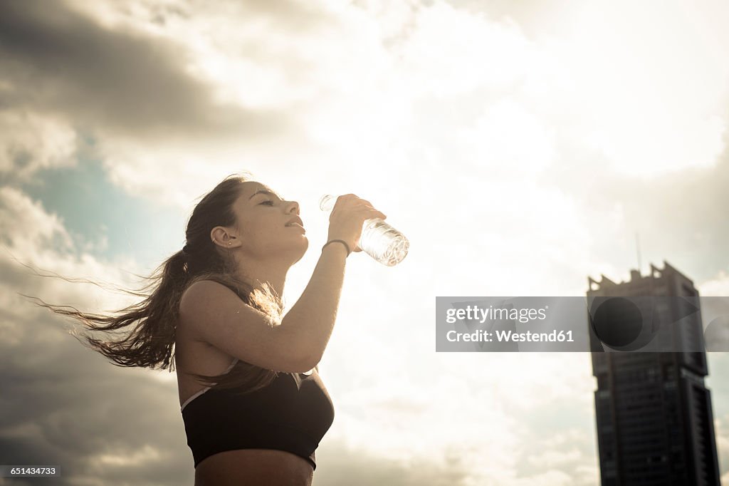 Athletic teenage girl drinking water from bottle