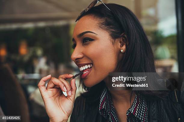 portrait of smiling young woman eating chocolate in a cafe - chocolate eating stock pictures, royalty-free photos & images