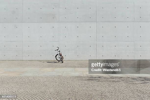 germany, berlin, bicycle parking in front of concrete wall at government district - pared de cemento fotografías e imágenes de stock