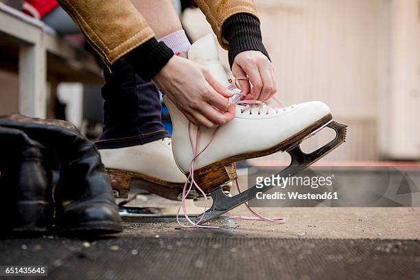 close-up of woman putting on ice skates - eislaufen stock-fotos und bilder