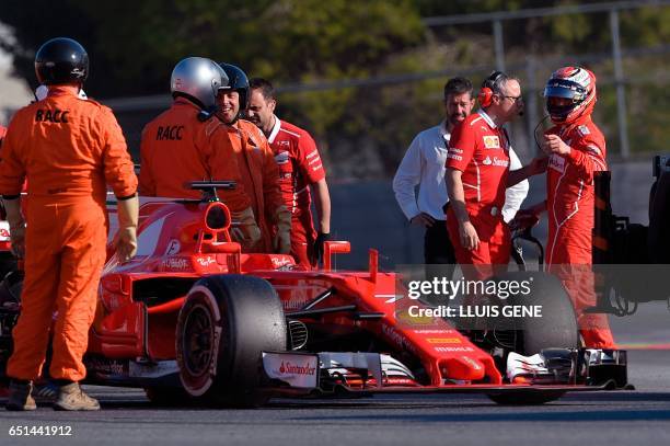 Ferrari's Finnish driver Kimi Raikkonen speaks with a staff member past his car at the Circuit de Catalunya on March 10, 2017 in Montmelo on the...