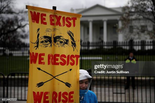 Protester holds a sign in front of the White House during a demonstration against the Dakota Access Pipeline on March 10, 2017 in Washington, DC....